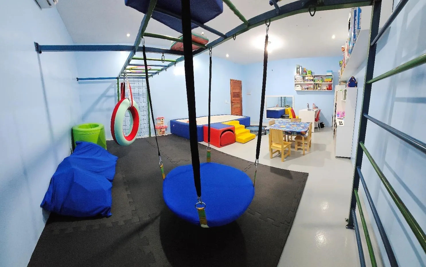 Balanço de disco, argolas e colchonetes na sala de Terapia Ocupacional.